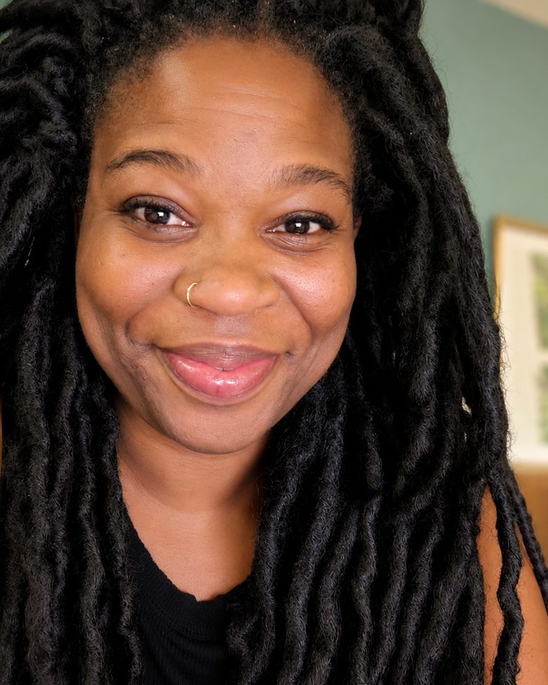 Charisse Fontes, Bay Area birth doula and childbirth educator, smiling in a plant-filled room